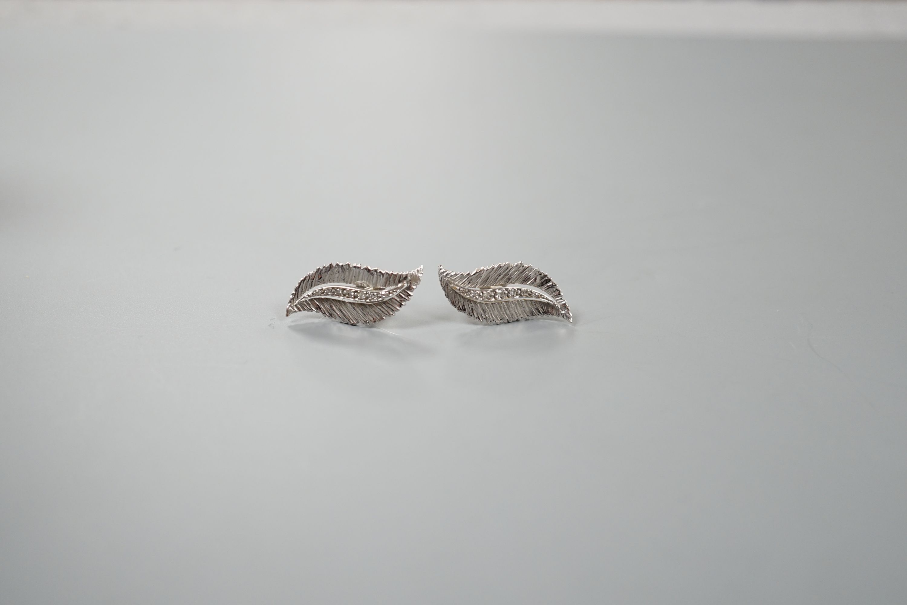 A pair of 9ct white gold and diamond chip set leaf earring, 22mm, gross weight 4.7 grams.
